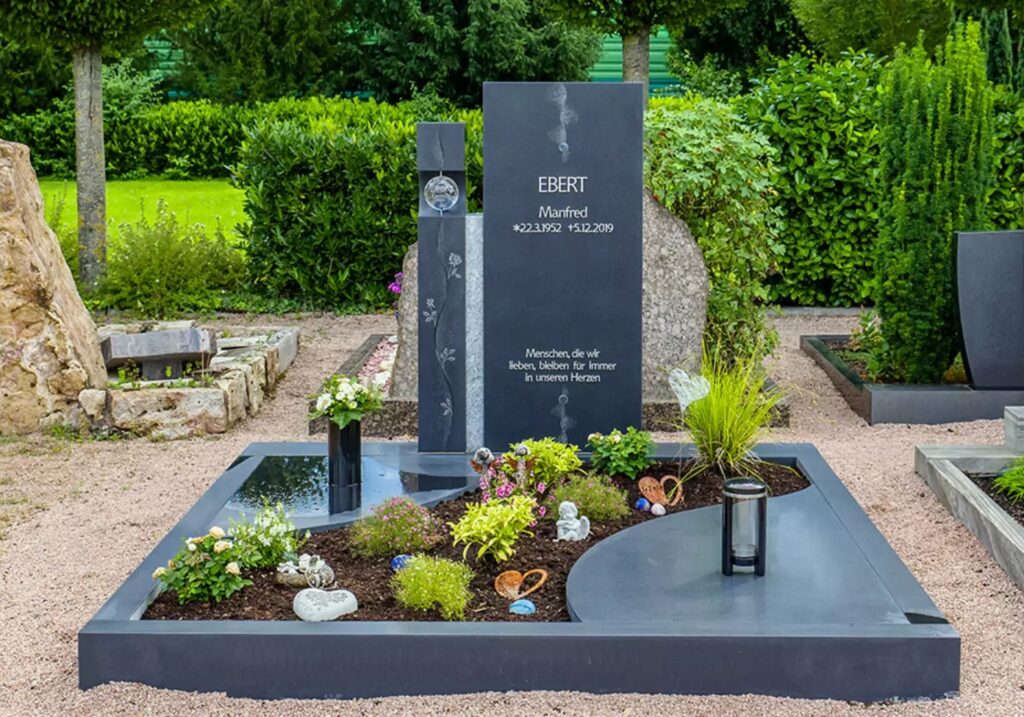Doppelgrabstein aus schwarzem Granit mit Glaskugel und Edelstahl - Einfassung und Abdeckplatten als Grabgestaltung - Friedhof Dienheim