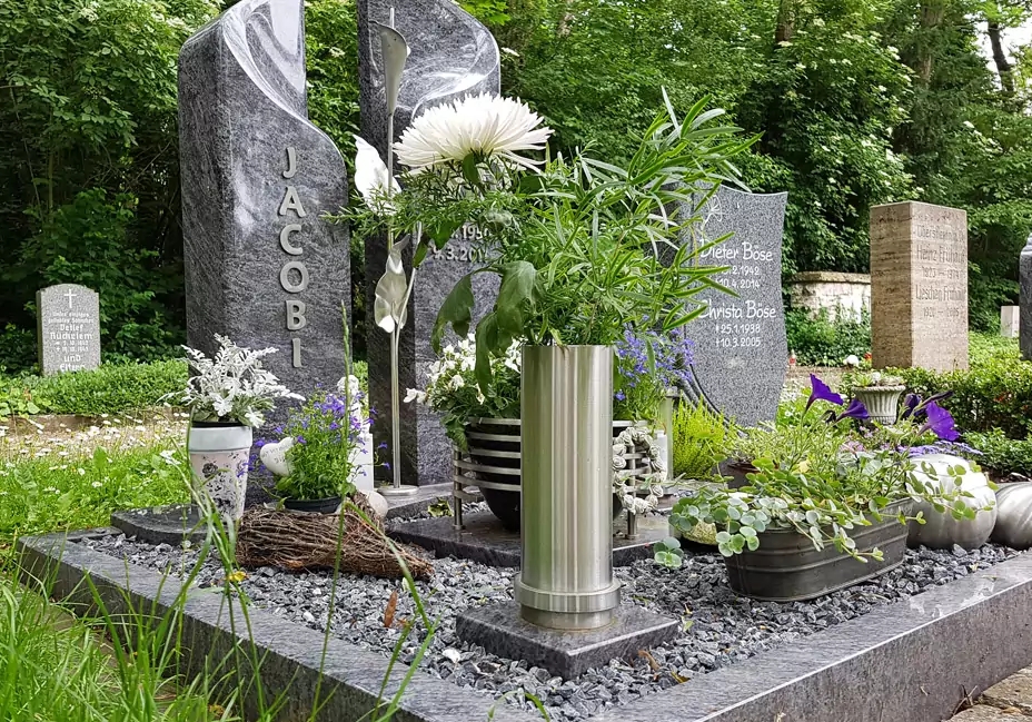 Schön geschmücktes Einzelgrab pflegeleicht mit vielen bepflanzten Grabschalen und Grabvasen aus Metall und Stein.