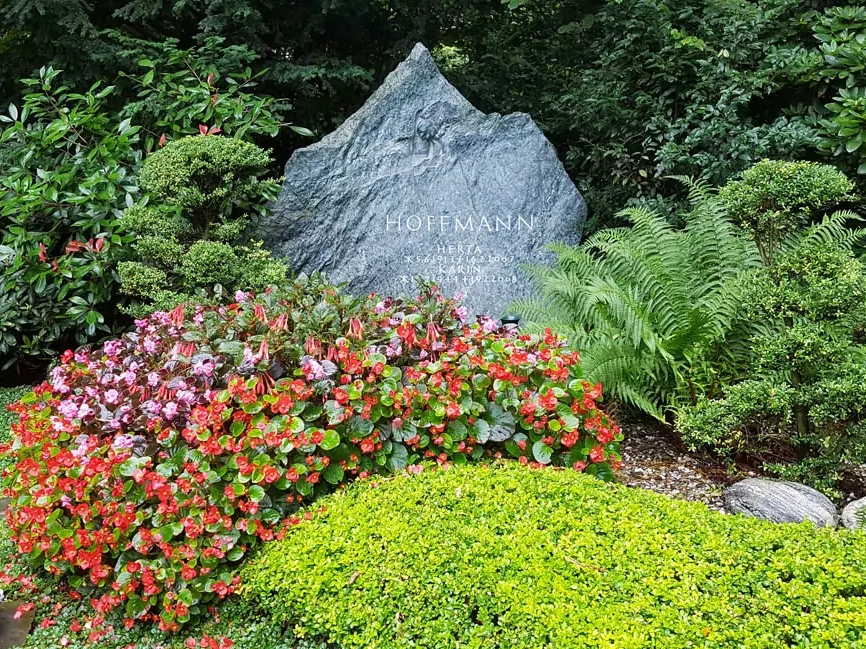 Familiengrabstätte mit Findling aus Granit - schöne Grabgestaltung für den Sommer auf dem Südfriedhof Köln.