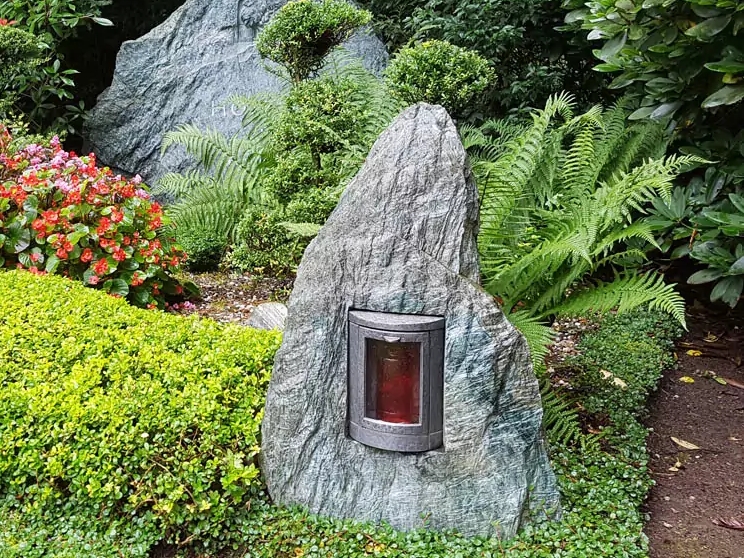 Familiengrabstätte mit Findling aus Granit - schöne Grabgestaltung für den Sommer auf dem Südfriedhof Köln.