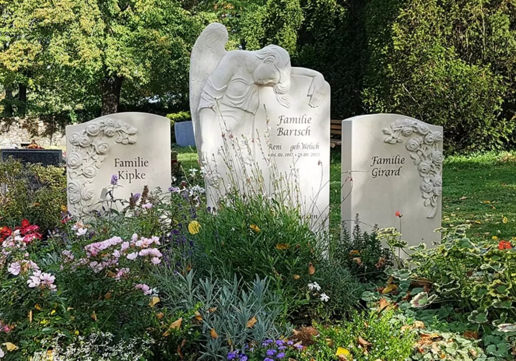 Familiengrabstätte mit drei hellen Grabsteinen aus Sandstein - Rosen & Engel Motive 