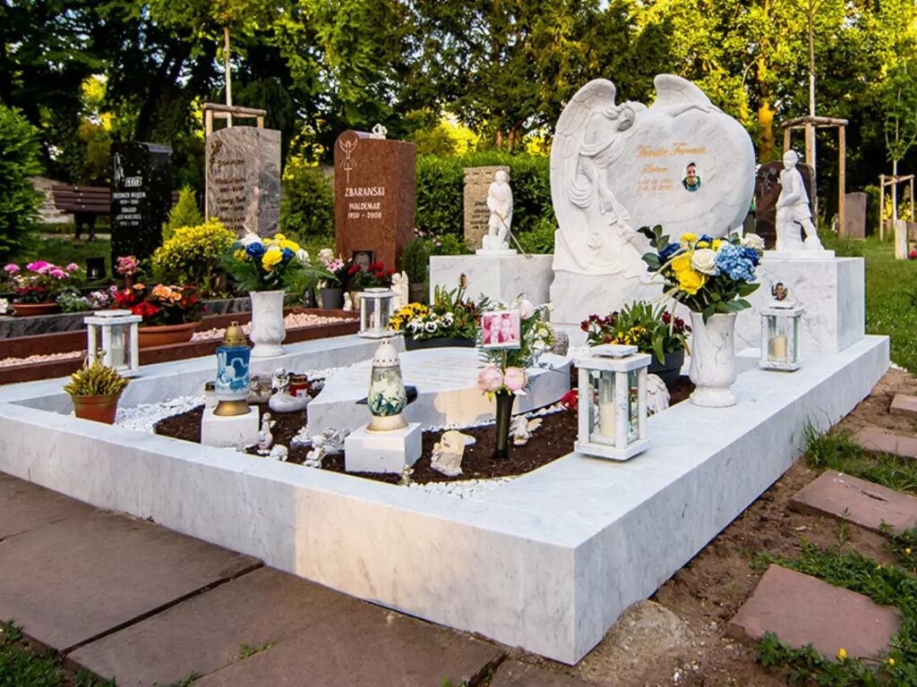 Grabengel auf einer Doppelgrabanlage aus weißem Carrara-Marmor mit Einfassung und üppigem Grabschmuck - Friedhof Mannheim