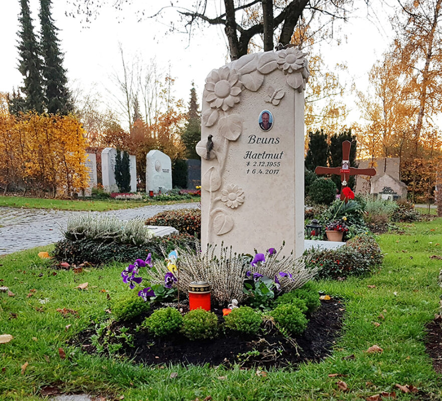 Grabstein für ein Urnengrabstelle aus hellem Kalkstein - Sonnenblumen und Bronzevögel