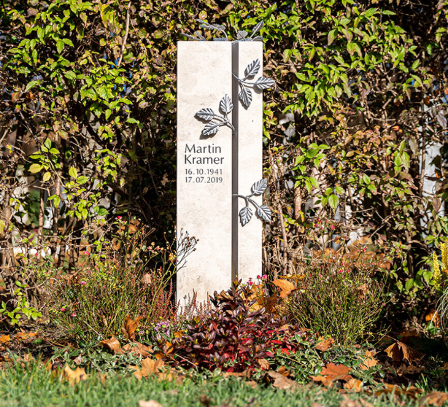 Moderne Grabstele aus Kalkstein für ein Urnengrab mit Blattranke aus Edelstahl