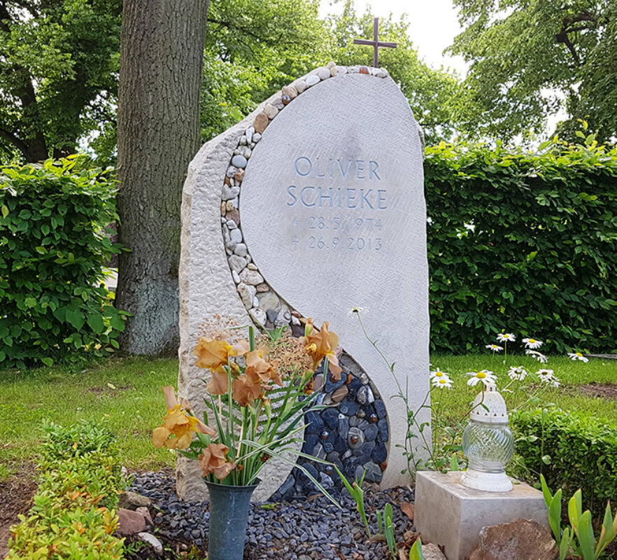 Außergewöhnlicher Grabstein aus hellem Kalkstein mit einer Linie aus Kieselsteinen