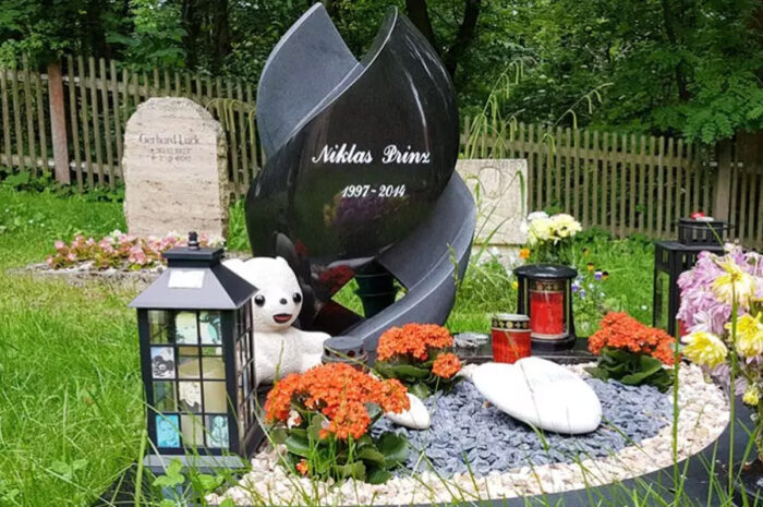 Moderner Grabstein für ein Kindergrab aus schwarzem Granit als Spirale gedreht mit Einfassung.
